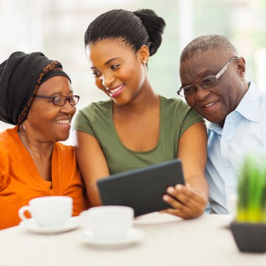 cheerful african family at home using tablet pc